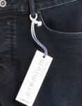 Детайл на тъмносини и прави дънки, предна част. Има поставен етикет на предния джоб, който чете: "Премиум деним".