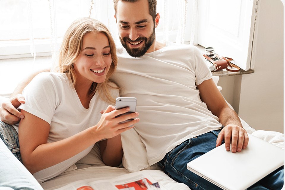 Мъж и жена гледат заедно смартфон.